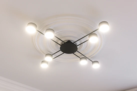 Électricien professionnel en gants de protection installant des prises électriques murales dans un intérieur résidentiel